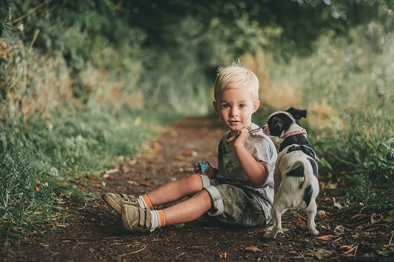Litet barn med hund under varm utomhusfotografering av Alnwick Photo