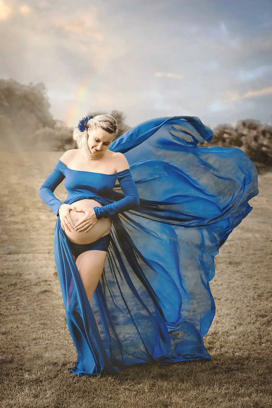 Konstnärlig gravidfotografering med blått tyg och dramatisk himmel av Alnwick Photo